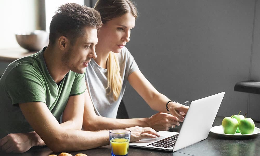 Couple looks at laptop and points at something