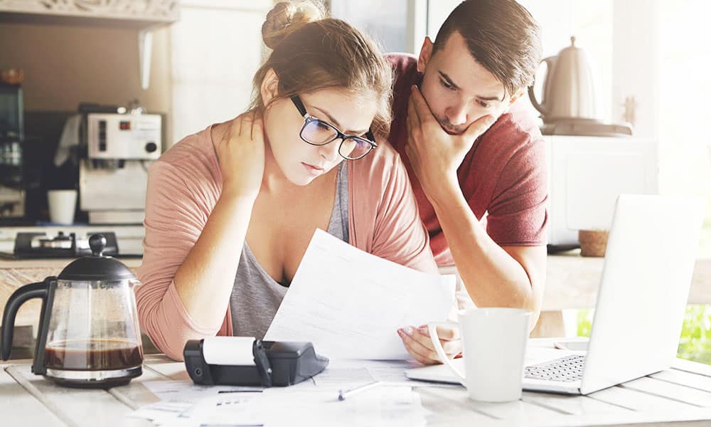 Young couple looking at papers in kitchen